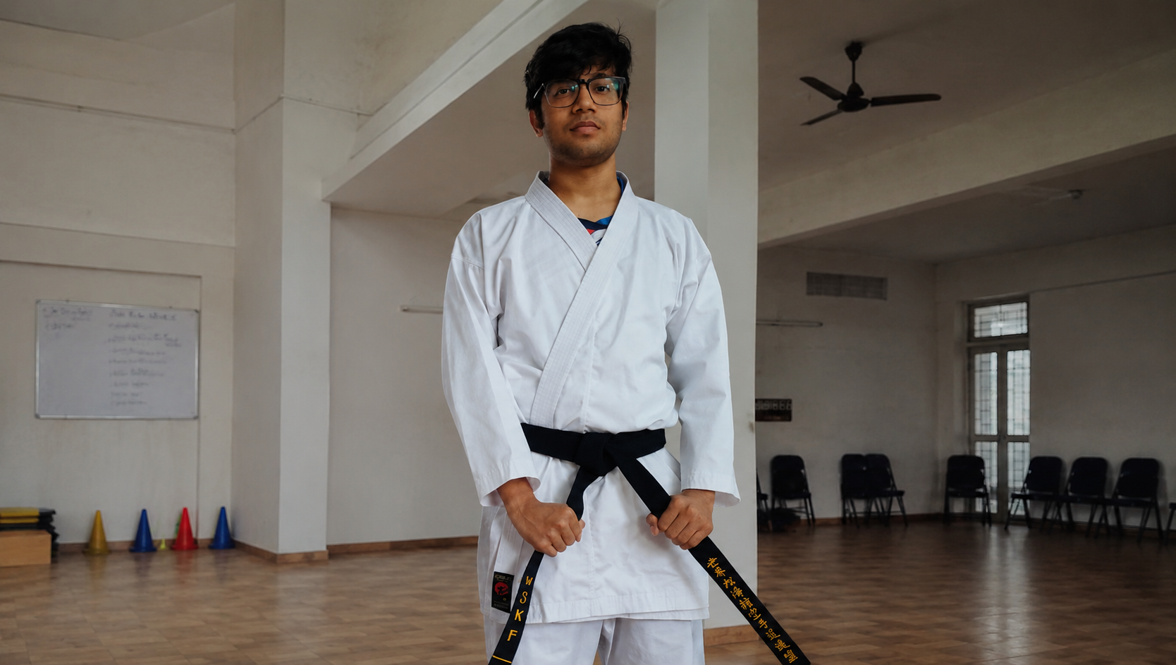 Joshua in a karate gi wearing his black belt